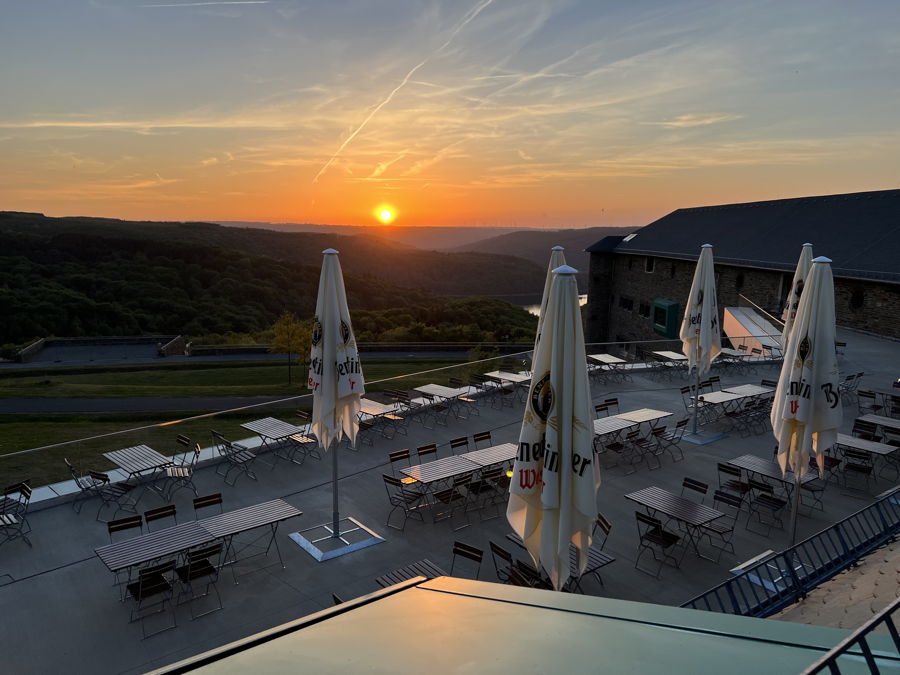 Blick in den Sonnenuntergang auf der Panaromaterrasse dess Restaurant Vogelsang auf der Burg Vogelsang in der Eifel.