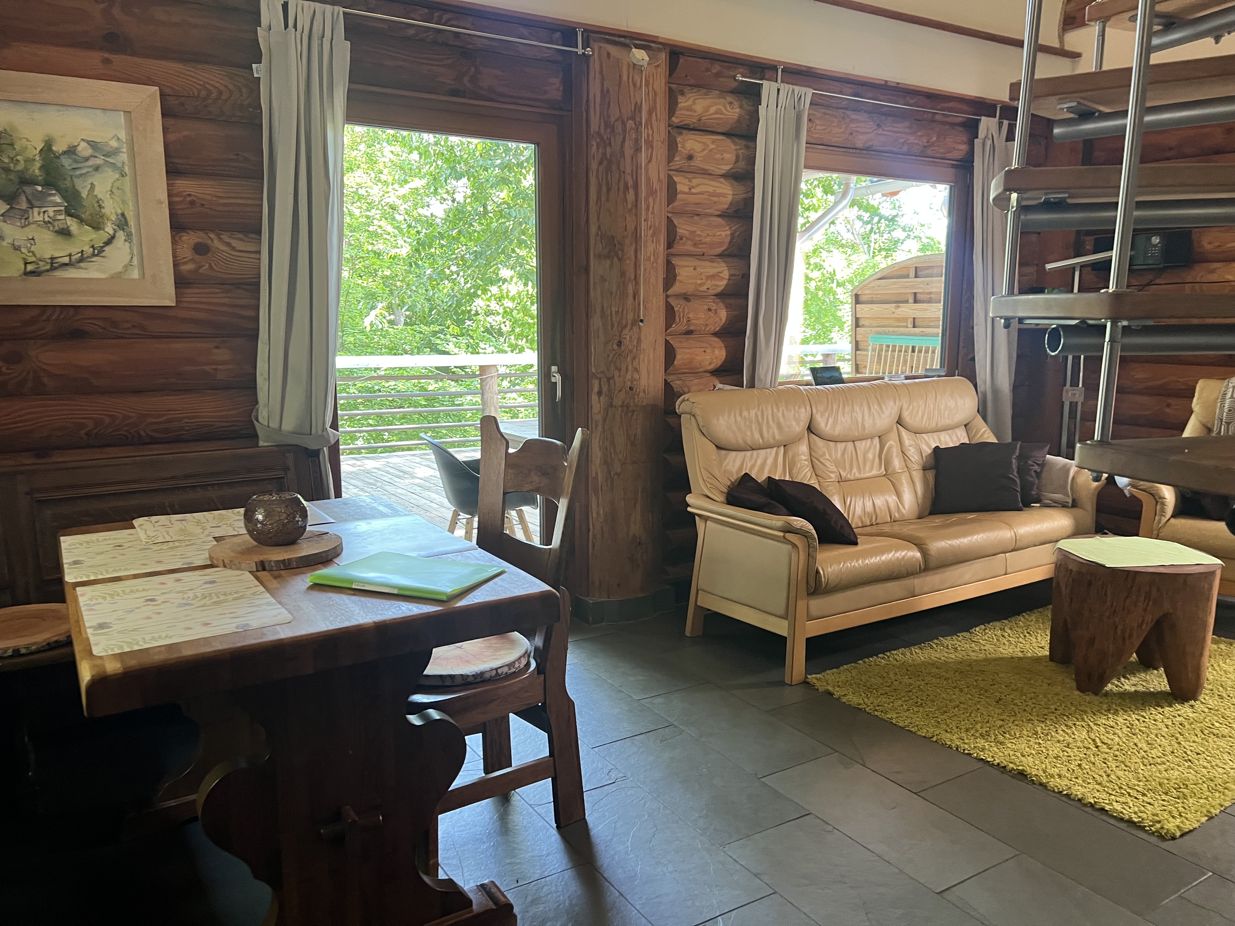 Schön eingerichtetes Wohnzimmer mit offener Küche und Zugang zur Terrasse.